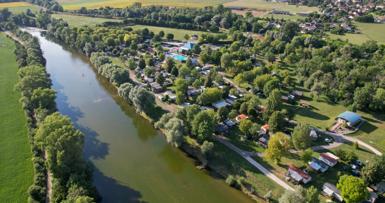 Vue aérienne du camping les Bords de Loue en bord de rivière dans le Jura