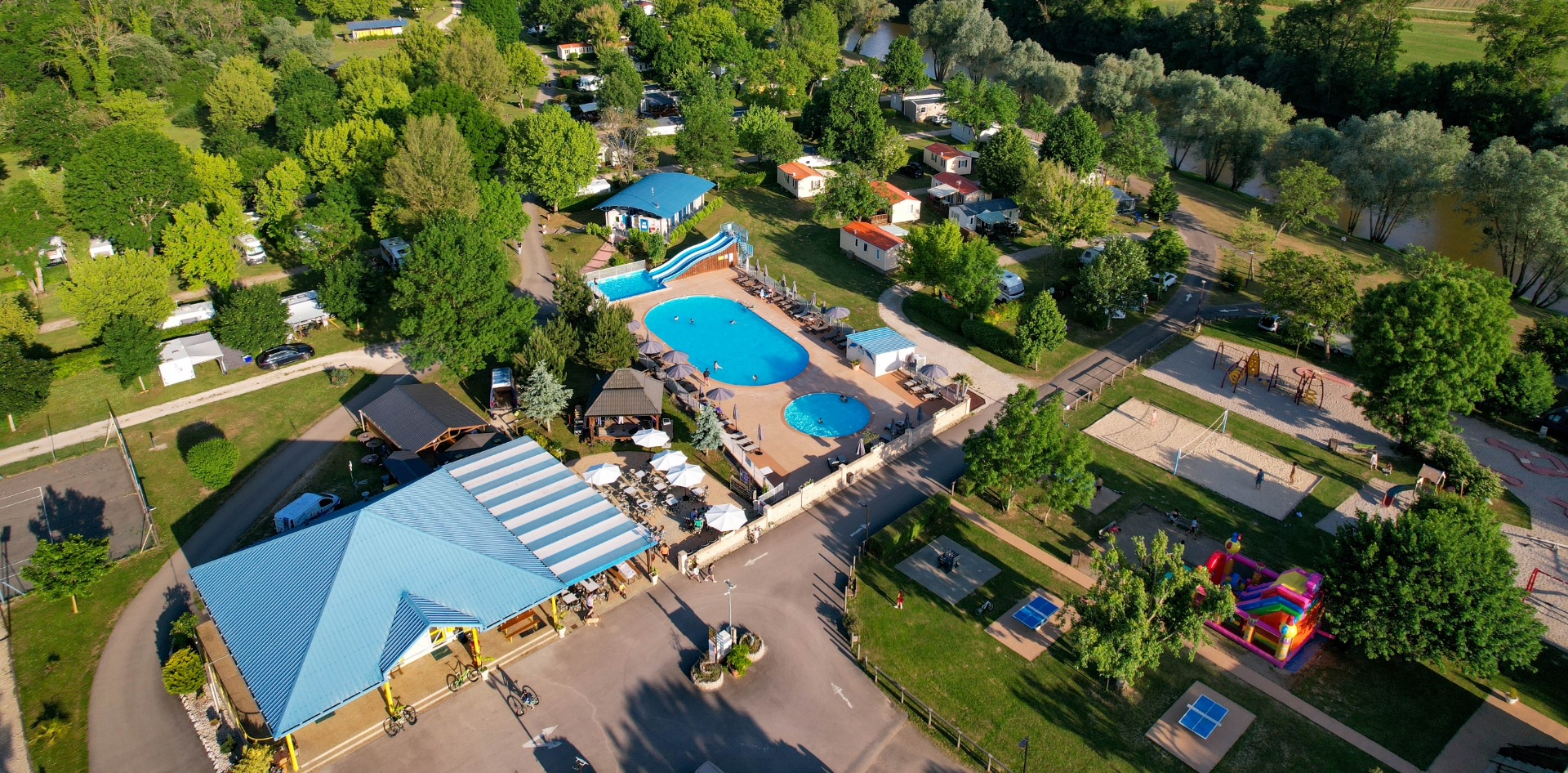 Luftbild des Campingplatzes am Ufer des Flusses Loue und am Waldrand