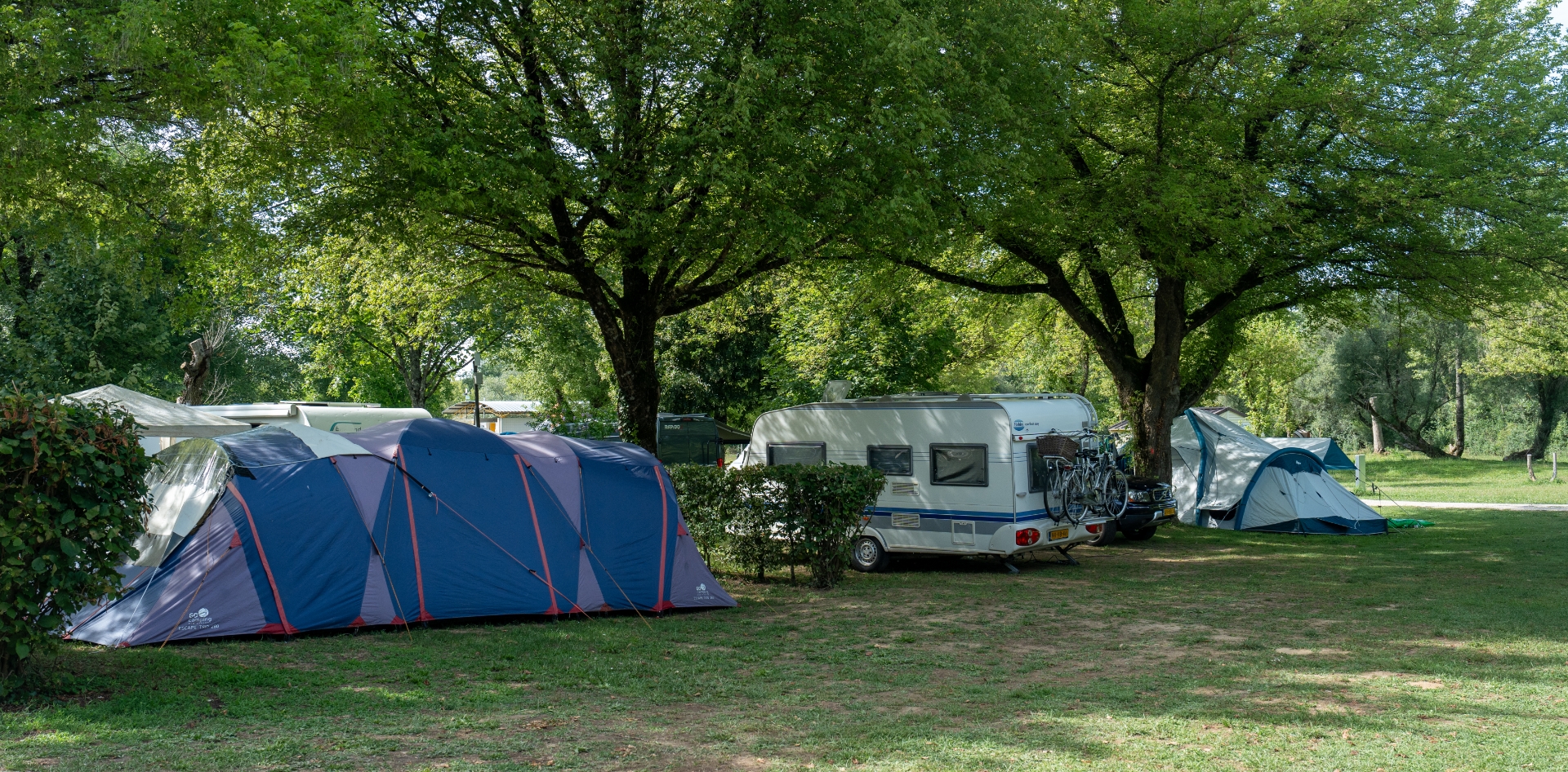 Die Stellplätze für Zelte und Wohnwagen des Campingplatzes Les Bords de Loue im Jura