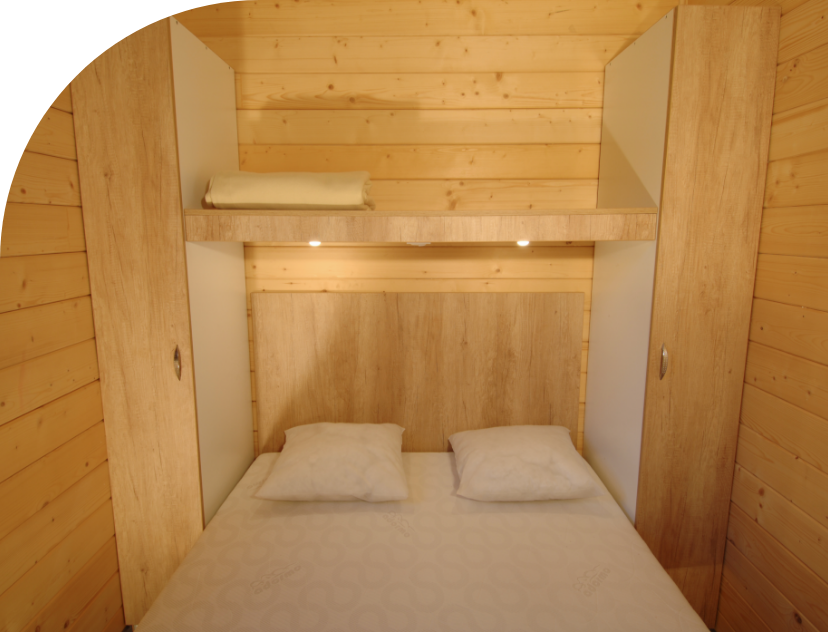 Bedroom with 1 double bed in the Monia Chalet to rent at Les Bords de Loue campsite in Jura