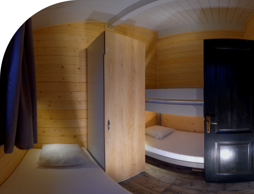 Kamer met 1 eenpersoonsbed en 1 stapelbed met 2 slaapplaatsen en opbergruimte in chalet Monia, te boeken op camping 