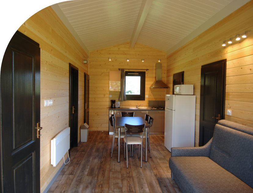 Kitchen area and living room in the Savania Chalet to rent at Les Bords de Loue campsite in Jura