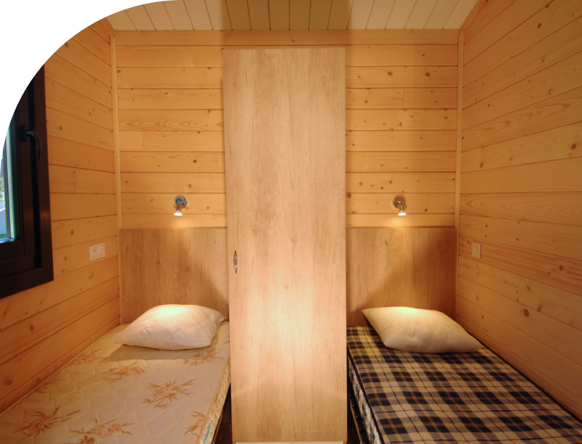 Bedroom with 2 single beds in the Savania Chalet to rent at Les Bords campsite in the Bourgogne-Franche-Comté region
