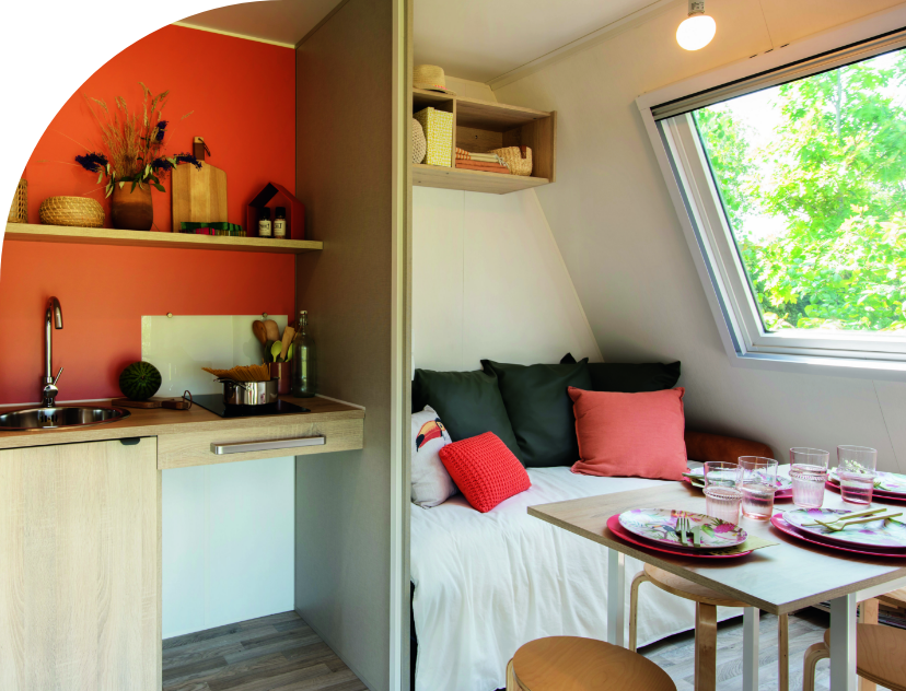 L’Espace cuisine et l’espace salon - salle à manger du Coco Chrono, location hébergement insolite au camping les Bords de Loue en région Bourgogne-Franche-Comté