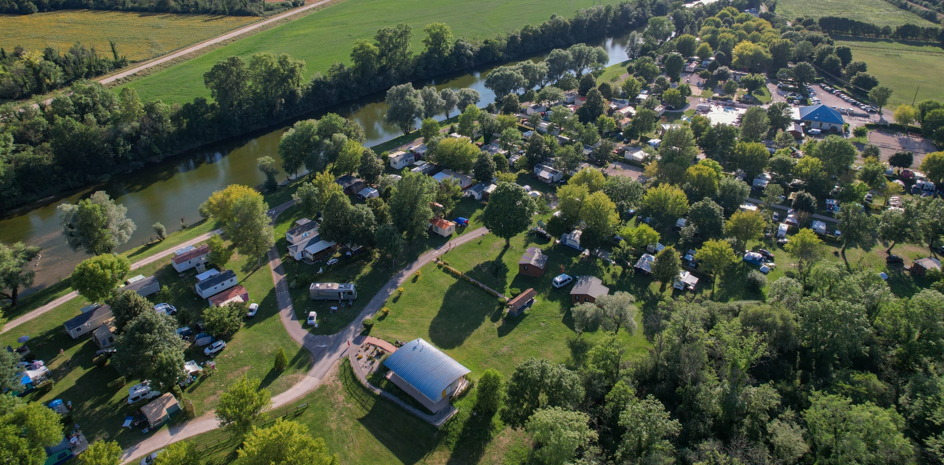Aerial view of the chalets and mobile-homes to rent at Les Bords de Loue campsite in Jura