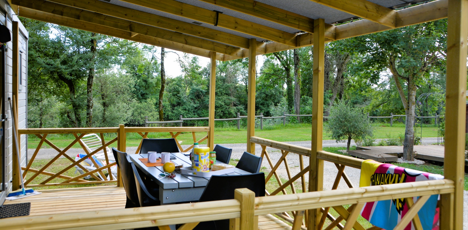 La terrasse du mobil-home 2 chambres en location au camping les Bords de Loue dans le Jura