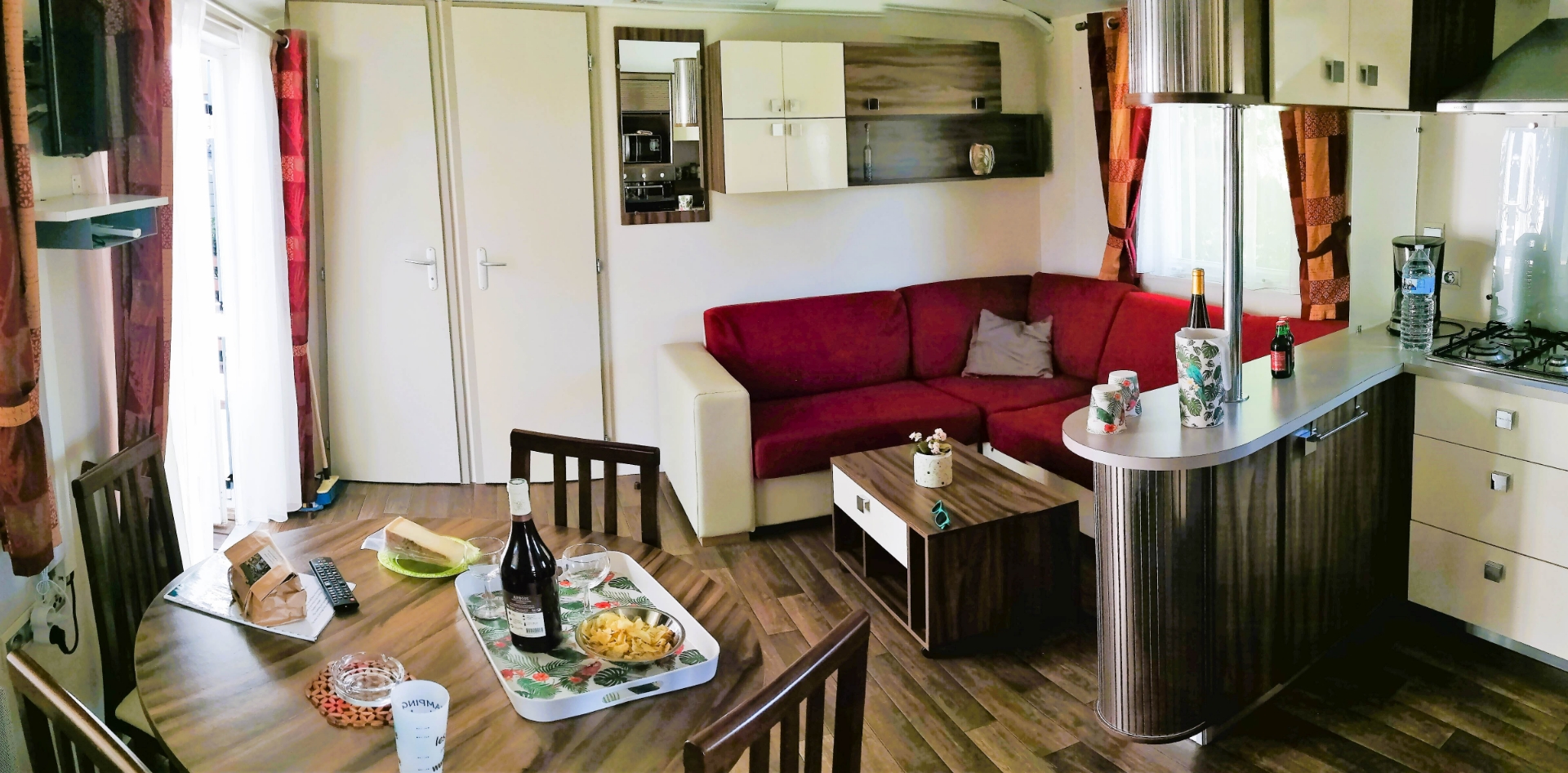 Salon et coin cuisine du mobil-home Privilège 2 chambres, location vacances dans le Jura