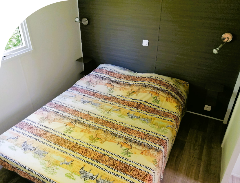 Bedroom with 1 double bed in the Trio mobile home to rent at Les Bords de Loue campsite in the Bourgogne-Franche-Comté region 
