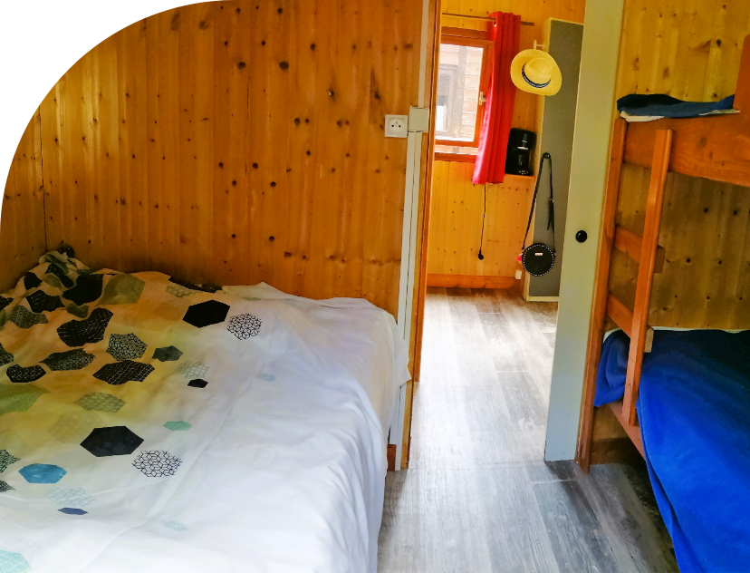 Bedroom with single bunk beds for 2 in the Petit Chalet to rent at Les Bords de Loue campsite in the Bourgogne-Franche-Comté region