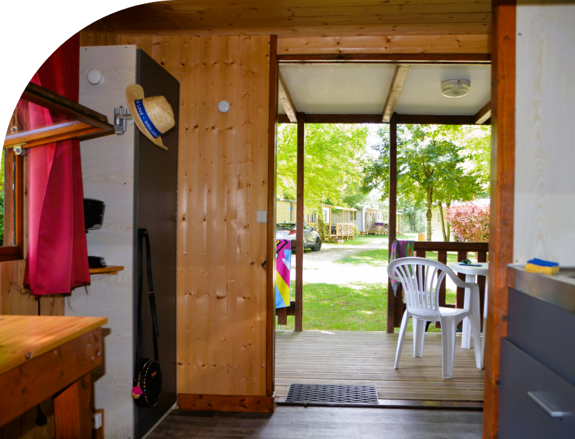Ansicht des Küchenbereichs und der überdachten Terrasse des kleinen Chalets, zu vermieten auf dem Campingplatz Les Bords de Loue
