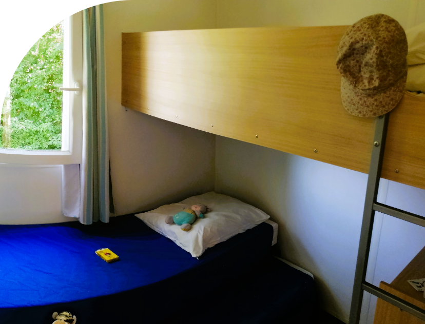 Bedroom with 1 single bed, 1 pullout bed and 1 bunk bed in the Tithome to rent at Les Bords de Loue campsite in the Bourgogne-Franche-Comté region