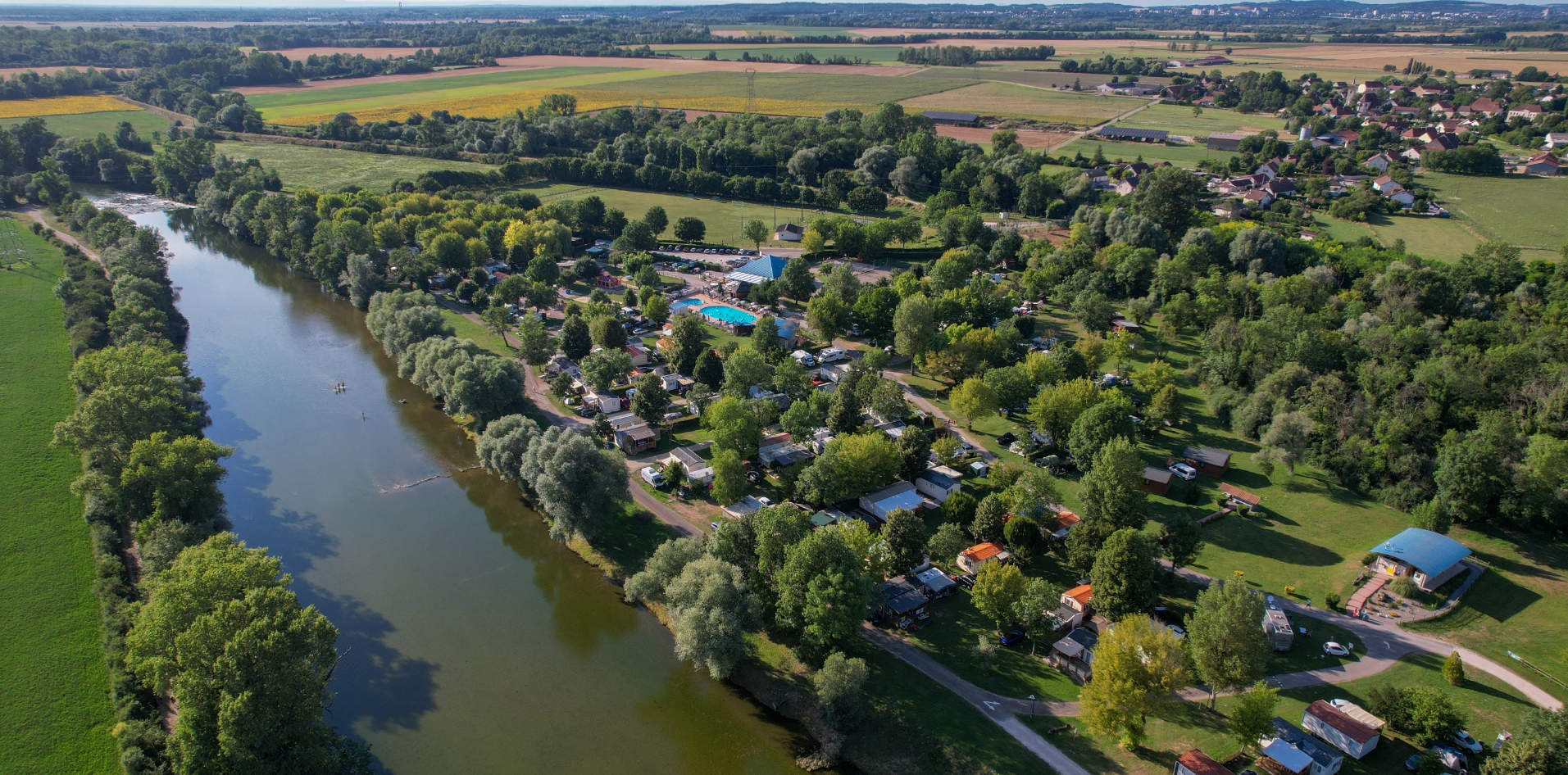 Luftbild des Campingplatzes Les Bords de Loue, Ihrem Campingplatz im Jura, inmitten einer vielfältigen Landschaft mit grünen Hügeln